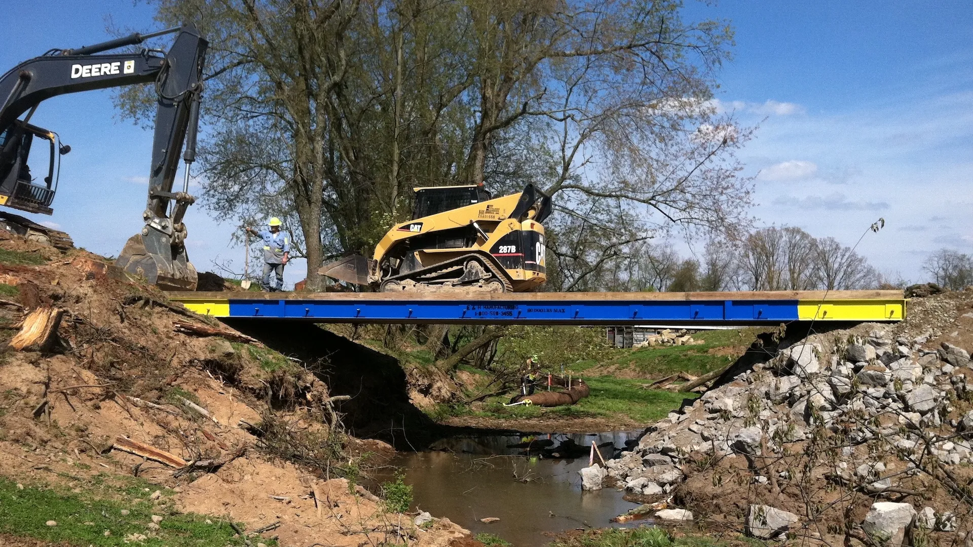 Skid steer crossing bridge during installation