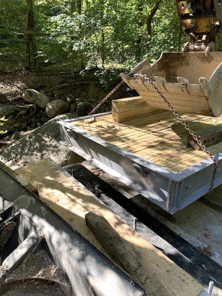 Excavator setting the first bridge panel