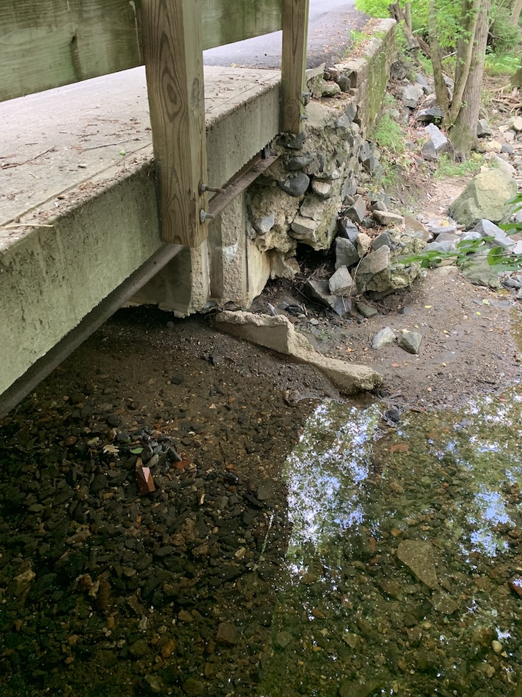 Collapsed concrete bridge abutment with exposed rebar