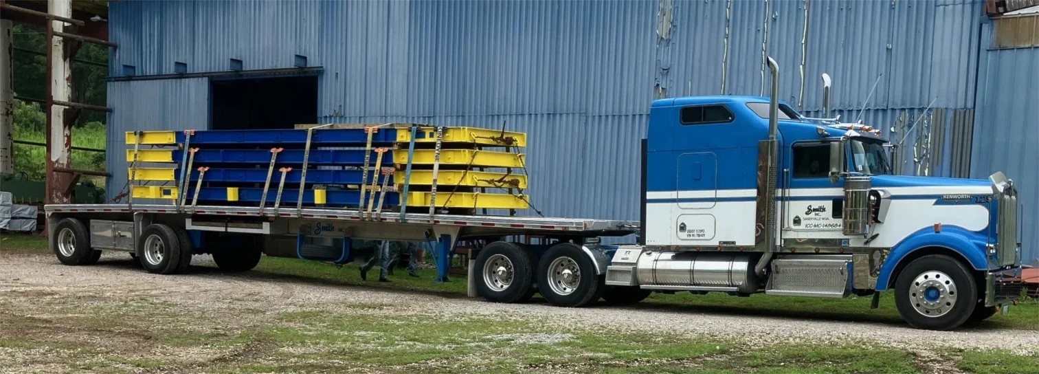 Bridge panels loaded on flatbed truck.